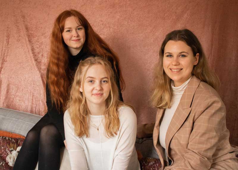 Reportrar Alice, Victoria och Paula sitter ner framför en rosa bakgrund.