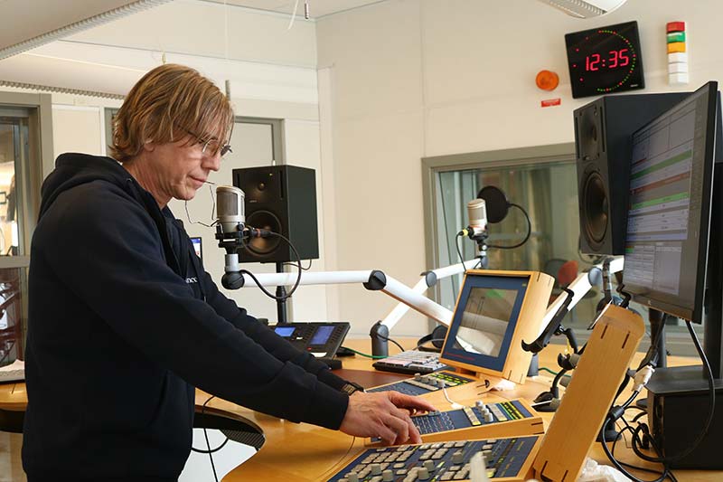 Joakim Johansson står i studion på P4-Kalmar och drar i reglarna på mixerbordet.